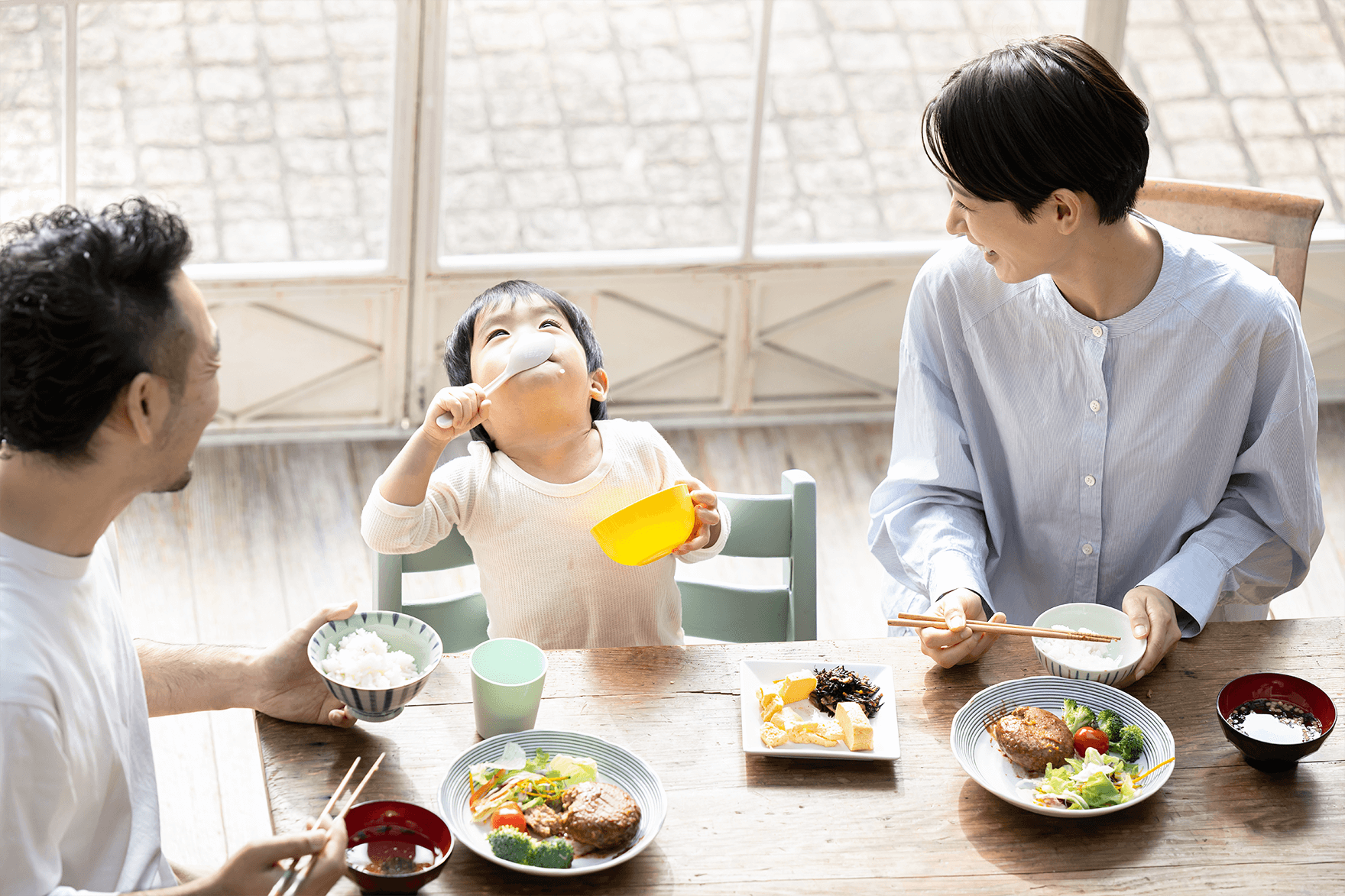 楽しそうに食事をする家族のイメージ写真